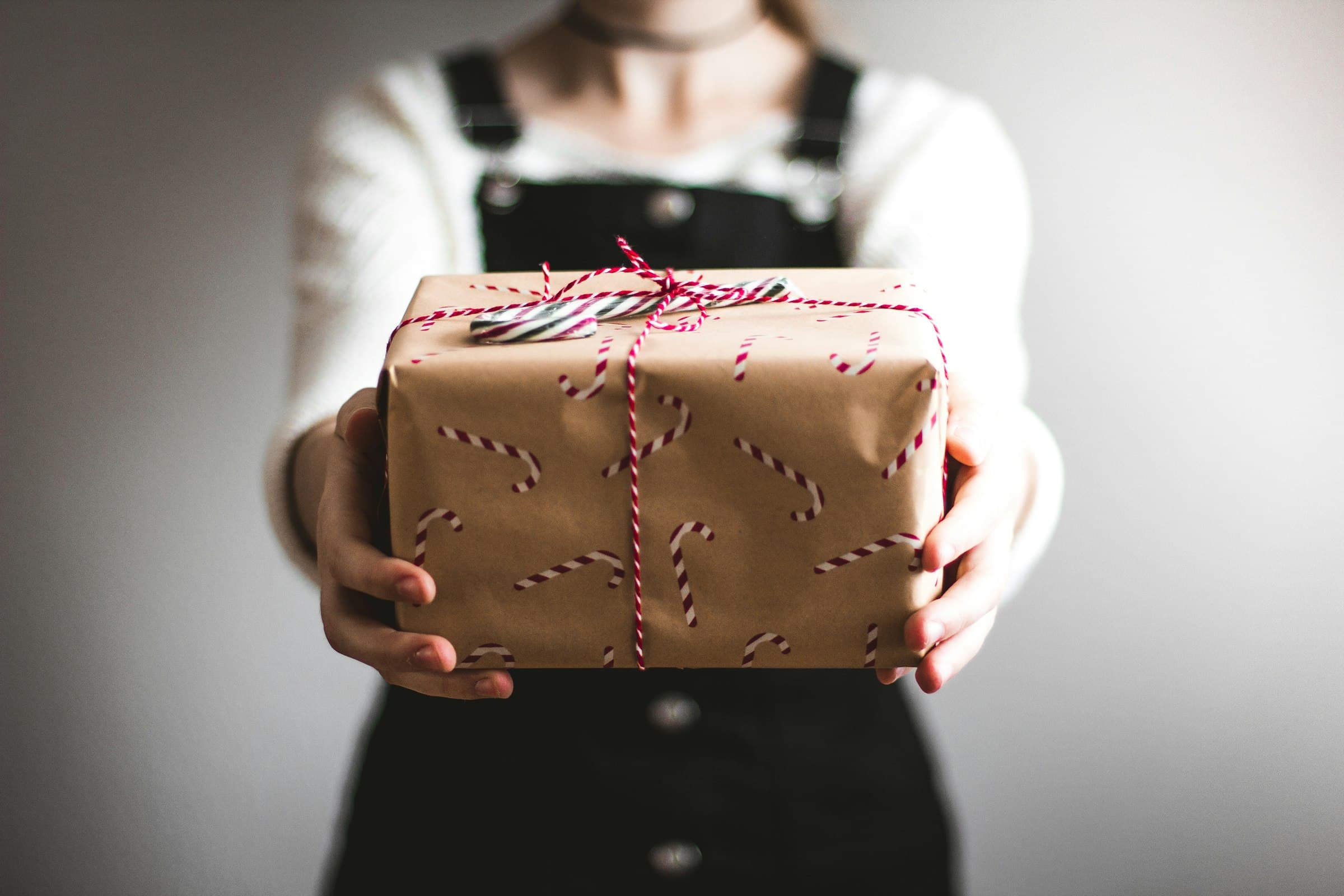 Person hält ein verpacktes Geschenk