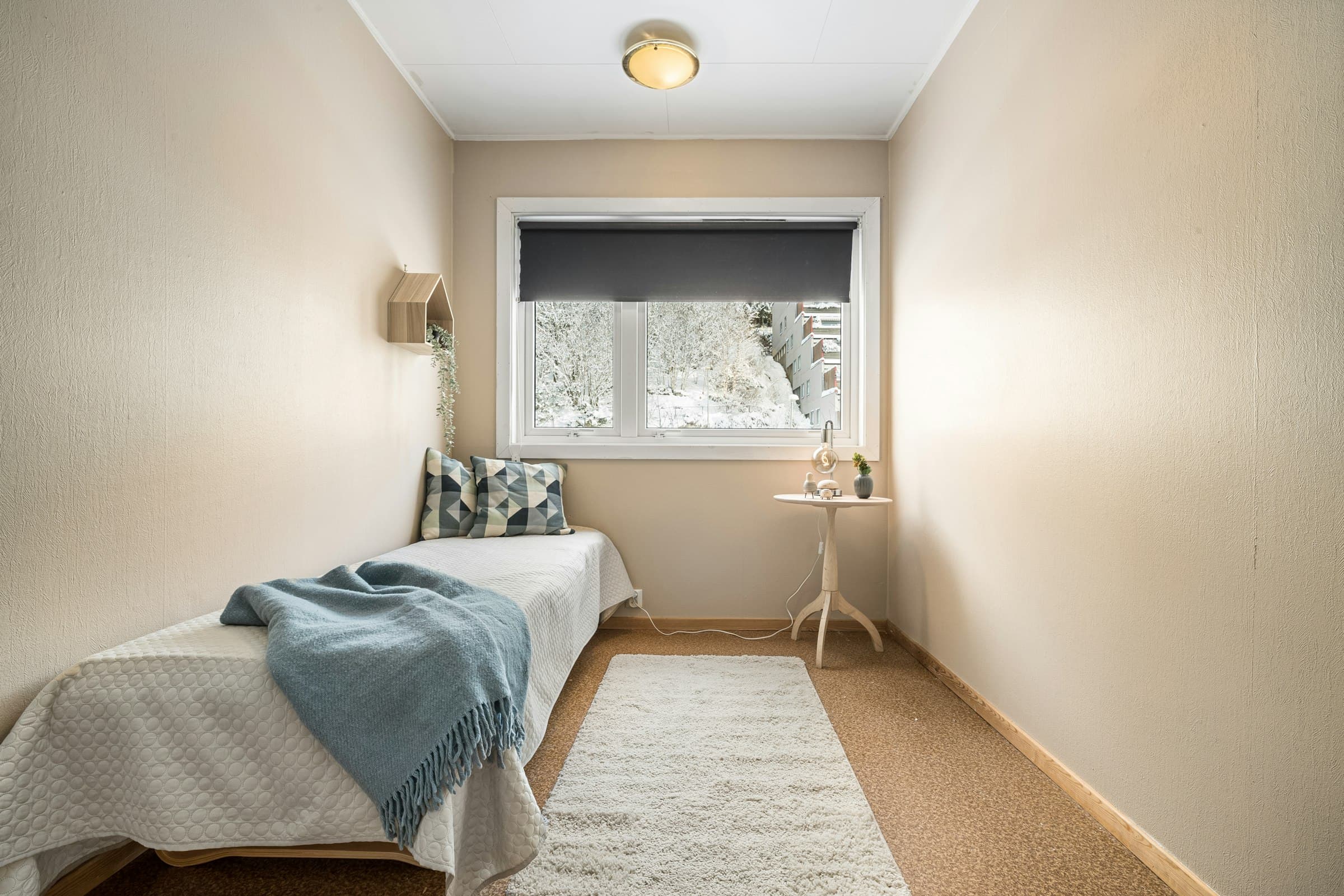 Schlichtes Zimmer mit gemachtem Bett